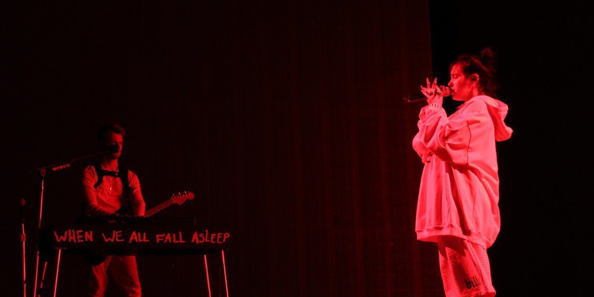 Billie Eilish performing live on stage at a Red Rocks concert in 2019