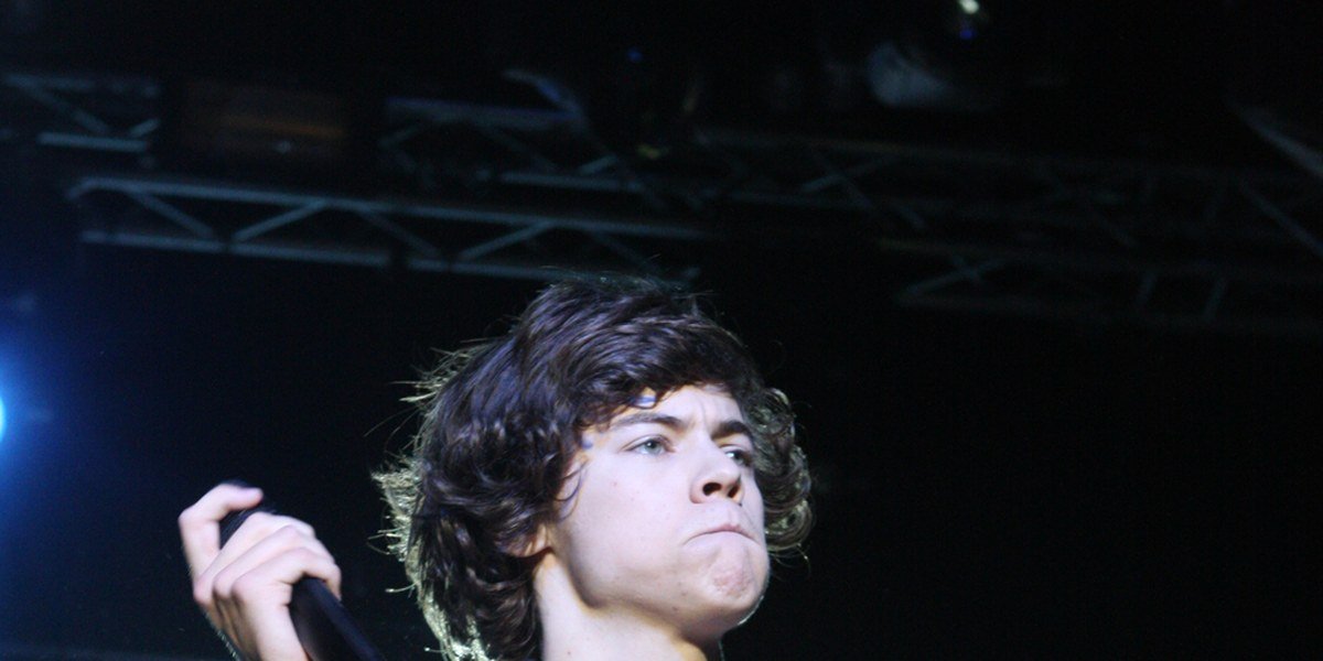 A young Harry Styles performing on stage with One Direction in Sydney, Australia in April 2012