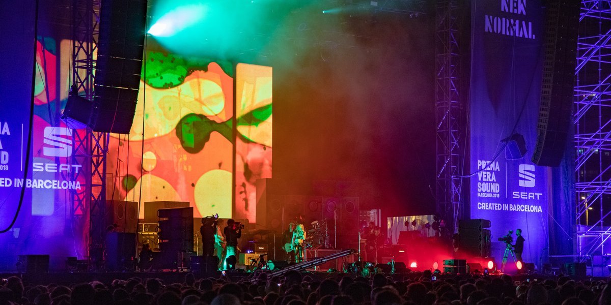 Miley Cyrus on stage in front of a large crowd with green and blue lights at Primavera Sound 2019